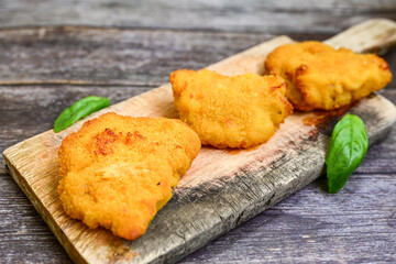 
 Crispy  deep fried home made  mini   chicken Cordon bleu with cheese   and ham  and french fries on wooden rustic background.  