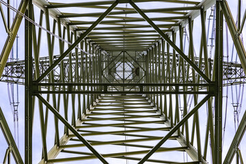 Zoom view up in high voltage pylon with patterns and steel girders