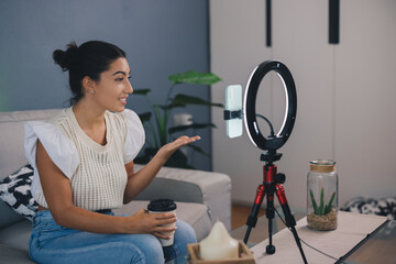 young female influencer creating content for the networks with her smartphone. female vlogger creating content with her smartphone