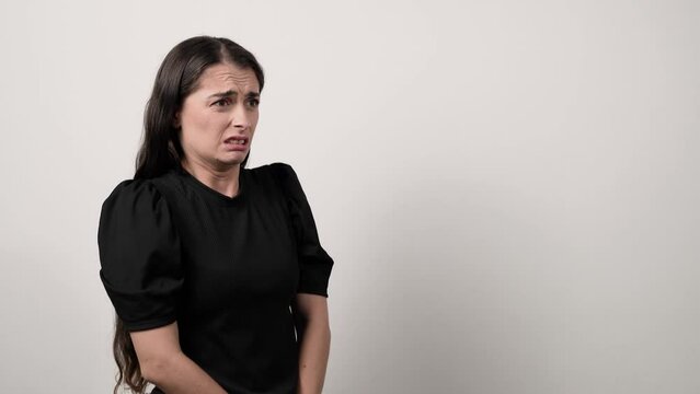White woman in black shirt is disgusted by something on white background