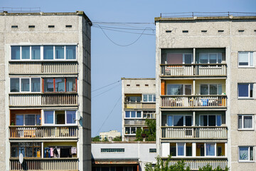 A fragment of the facade of an old apartment building in a poor area, cheap city quarter