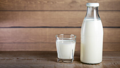 Milk bottle and milk glass on wooden table. Healthy eating concept