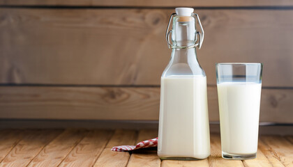 Milk bottle and milk glass on wooden table. Healthy eating concept