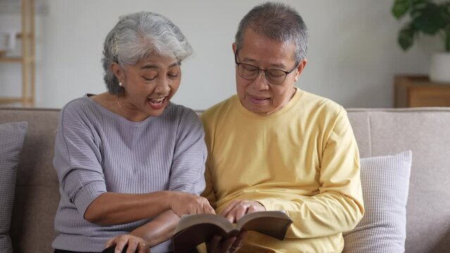 Senior couple reading a book at home, Retirement concept