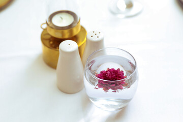 Restaurant table with purple flower in a glass.