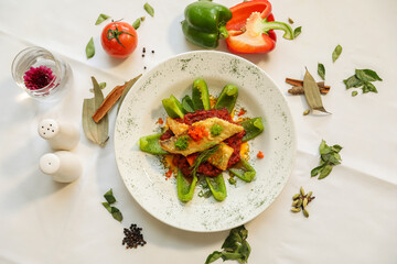 Cooked salmon, peppers vegetables served with tomato, cinnamon, and cardamom on a white background