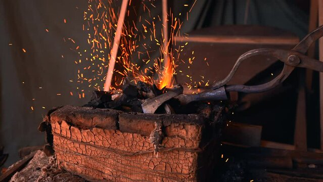 Hard work with iron. Media. A man on the street in a hat is working with fire and iron.