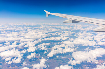 Obraz premium View from the airplane window at a beautiful cloudy sky and the airplane wing