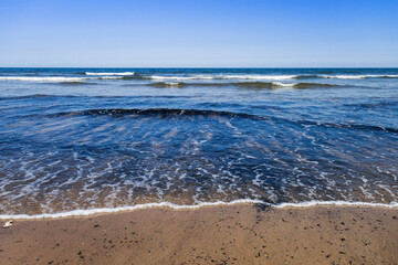 Cambois beach in Northumberland, UK with coal dust or dross from the mining heritage of the area.