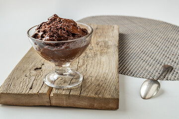 Chocolate mousse - traditional French dessert in a transparent bowl on a white table