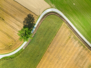 Aerial view of countryside road through fields in rural area in Switzerland.