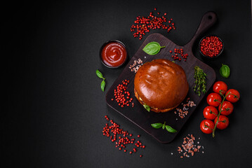 Burger with juicy beef cutlet, cheese, tomatoes, salt, spices and herbs