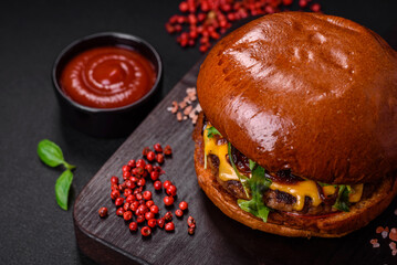 Burger with juicy beef cutlet, cheese, tomatoes, salt, spices and herbs
