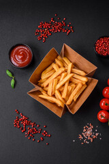 Delicious crispy french fries with salt and spices in a cardboard box