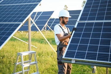 An Indian worker installs solar panels. The concept of renewable energy.