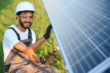 An Indian worker installs solar panels. The concept of renewable energy.