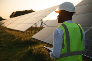 Fototapeta African american technician check the maintenance of the solar panels. Black man engineer at solar station. obraz
