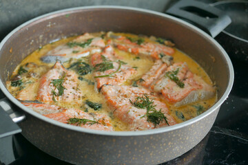 cooked salmon fish with cream on a cooking pan on a stove at kitchen 