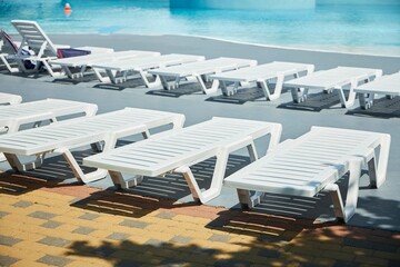 Beach chairs by the pool in the hotel or spa. Recreation and entertainment for the summer.