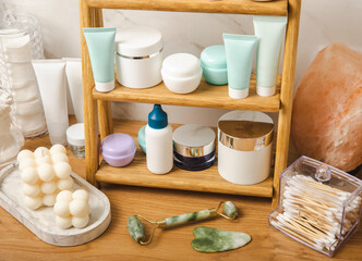Care cosmetics on the shelf in the bathroom. Cosmetic tube. Cleanser, face and body cream, face roller and gua sha, tonic. Shelf with cosmetics in the interior of the bathroom.Beauty concept. 