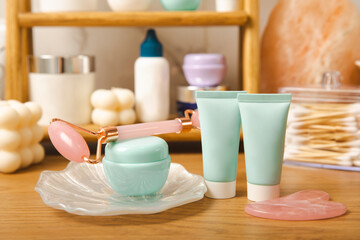 Care cosmetics on the shelf in the bathroom. Cosmetic tube. Cleanser, face and body cream, face roller and gua sha, tonic. Shelf with cosmetics in the interior of the bathroom.Beauty concept. 