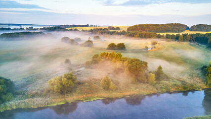 Aerial view of rural landscape with river and lush trees in fog - 622431360