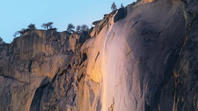 Panning view of wonderful Yosemite Firefall located in Yosemite National Park, California, USA. Breathtaking shot of Horsetail fall, occurs on the east side of El Capitan rock formation, 4k footage