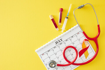 July 28th is World Hepatitis Day. Top view composition of calendar, awareness ribbon, stethoscope, blood samples, syringe on yellow background with empty space for text
