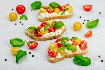 Fresh bread sandwiches with tomato cherry, cream cheese and basil leaves. Morning breakfast concept