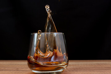 A beautiful splash of cognac in a glass on the table