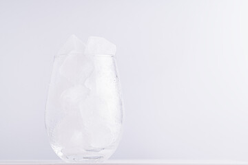Empty glass with ice cubes on a white background