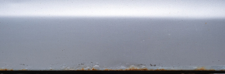 Rust at the bottom of a silver car door