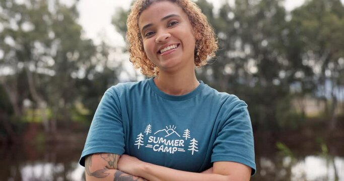 Smile, portrait of woman with arms crossed at summer camp and happy counsellor in nature with pride. Forest, lake and face of camping volunteer girl with confidence, support and leadership training.