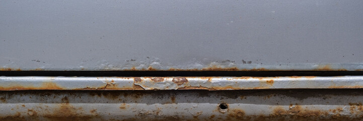 Rust on the silver door and threshold of the car
