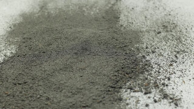Cement on a white background. Cigarette ash is like cement, a lot of dust. Sprinkled gray dust on a white background. Gray material, very thin