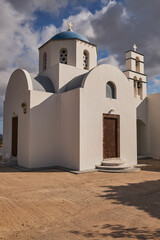 Fototapeta na wymiar Orthodox Church in Megalochori Village with a Blue Dome - Santorini Island, Greece