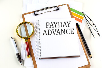 PAYDAY ADVANCE text on notebook with clipboard on white background