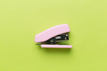 Pink stapler on color backgroung, top view