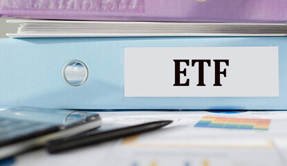 ETF - stock exchange text fund on office folder, workplace with a financial chart