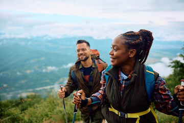 Black woman and her boyfriend hiking in mountains.