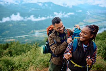 Multiracial couple enjoys in hiking day in nature.