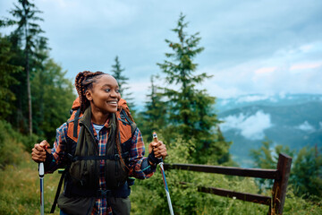 Happy black female hiker enjoys in walk in mountains. - Powered by Adobe