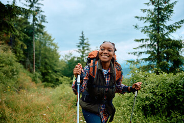 Young happy African American woman hiking in nature.
