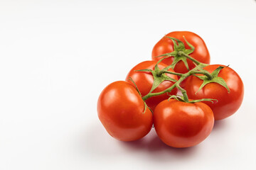 A sprig of fresh, beautiful, red tomatoes isolated on a white background.