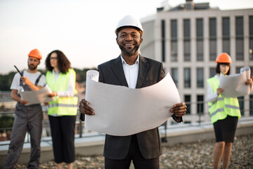 Portrait of african american investor dressed in business attire posing on camera with paper design...