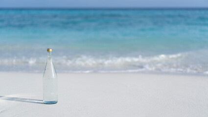 Glass bottle of pure water on the background of ocean