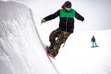 Snowboarder on an half-pipe slope