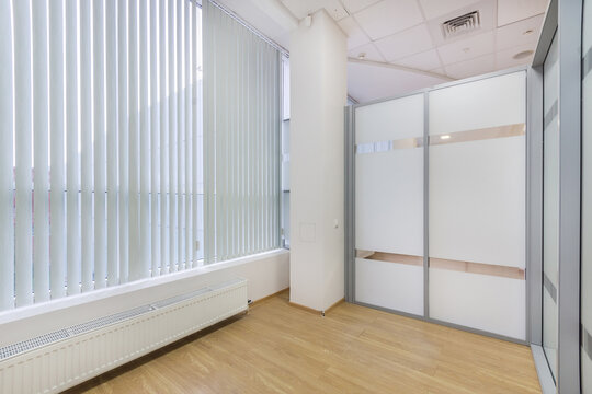 A small office with a modern design. Panoramic window with blinds. The room is ready to install furniture and appliances.