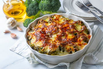 Casserole Cauliflower and broccoli baked with cheese sauce in a pot close-up on a wooden table. Horizontal top view from above. Broccoli gratin.