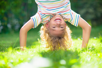 Little boy hanging upside down. Handstand exercise